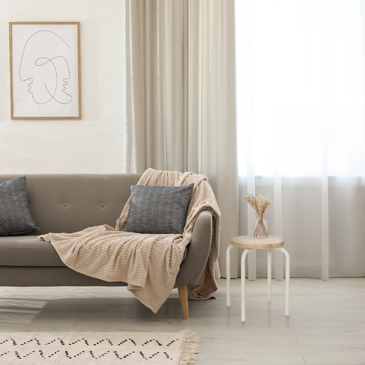 Sitzhocker ALRANDA in Weiß und Eiche neben einem Sofa von hjh LIVING