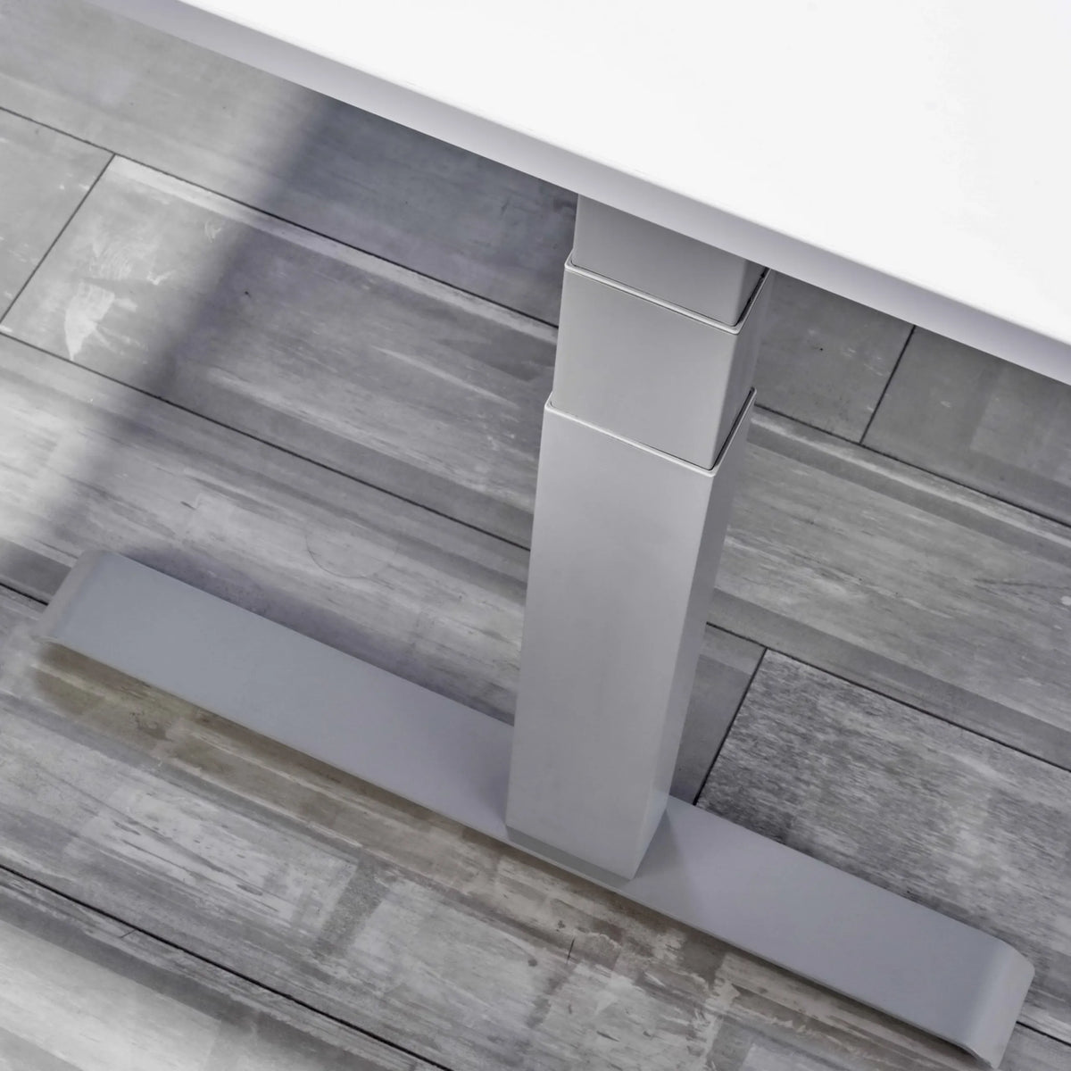 Höhenverstellbares Gestell des Schreibtischs XDKB 16 S in Grau auf grauem Holzboden von hjh OFFICE PRO